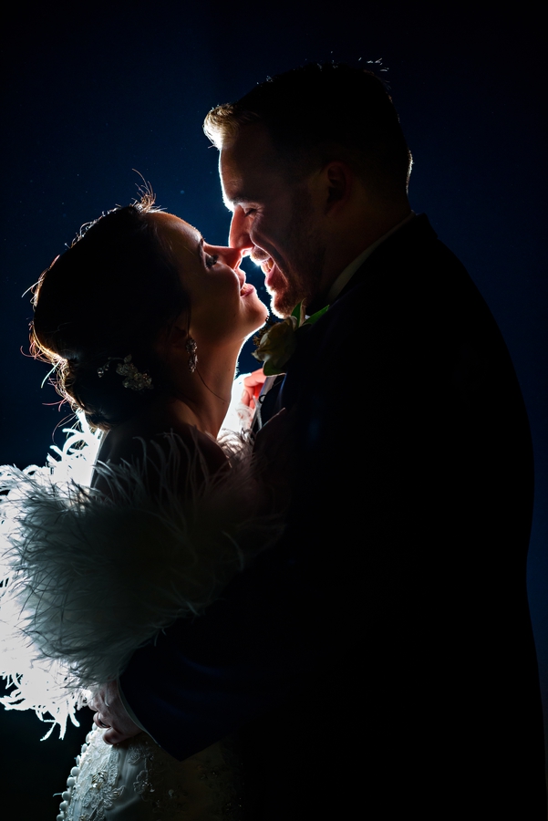 A bride and groom kiss in the moonlight after their wedding.